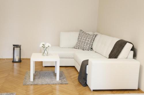 ein Wohnzimmer mit einem weißen Sofa und einem Tisch in der Unterkunft Apartman - Heart of Budapest in Budapest