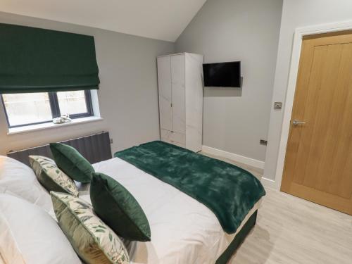 Un dormitorio con una cama con una manta verde. en Willow, en Hull