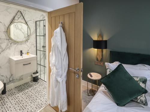 a bathroom with a bed and a sink and a shower at Willow in Hull