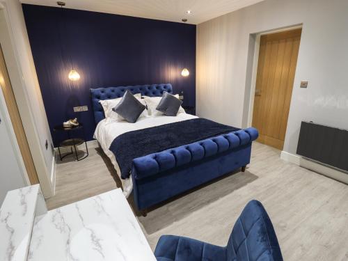 a bedroom with a blue bed and a blue wall at Wysteria in Hull