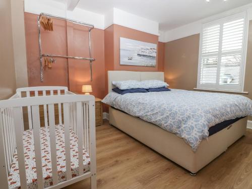 a bedroom with a bed and a crib at Glanffrwd - Nefyn in Pwllheli