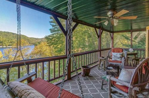 a screened in porch with a hammock and chairs at stayNantahala - Smoky Mountain Cabins in Aquone