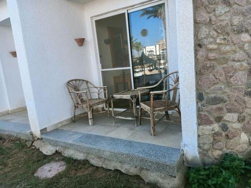 a patio with two chairs and a table and a window at ستديو رائع وهادي مزود بحديقه in Sharm El Sheikh
