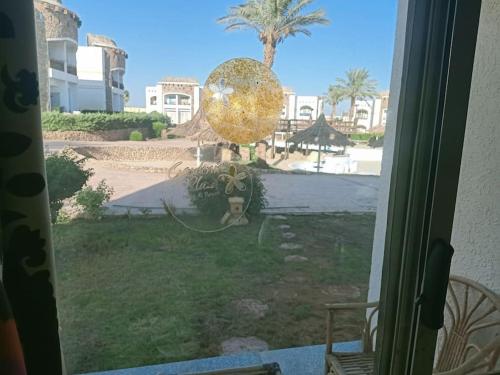 een raam met uitzicht op een tuin met een palmboom bij ستديو رائع وهادي مزود بحديقه in Sharm El Sheikh