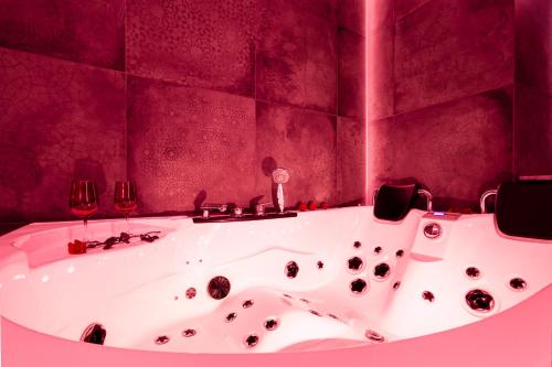 a bath tub in a bathroom with two wine glasses at Jacuzzi & Bike Apartment, Krakow in Krakow