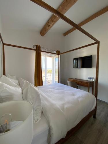 ein Schlafzimmer mit einem weißen Bett und einem Sofa in der Unterkunft O Bain Soleil in Bourg-Saint-Andéol