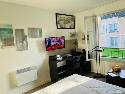um quarto com uma cama, uma secretária e uma janela em Appart Hôtel 3* dans une résidence de tourisme em Le Mée-sur-Seine