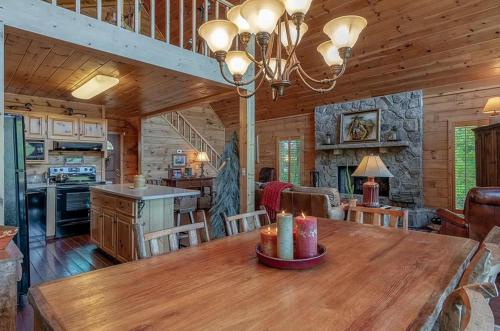 a kitchen and dining room with a large wooden table at stayNantahala - Smoky Mountain Cabins in Aquone