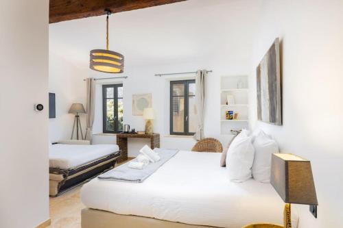 Dos camas en una habitación con paredes blancas. en Longue Vie Au Roi - Vue Enchanteresse, en Carcassonne