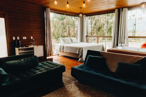 um quarto com uma cama, uma cama e um sofá em Recanto- Pousada Cachoeira da Neve em Urubici