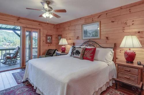 a bedroom with a bed and a ceiling fan at stayNantahala - Smoky Mountain Cabins in Aquone