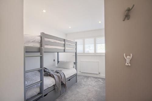 a bedroom with two bunk beds and a window at Trelights Port Issac in Saint Endellion