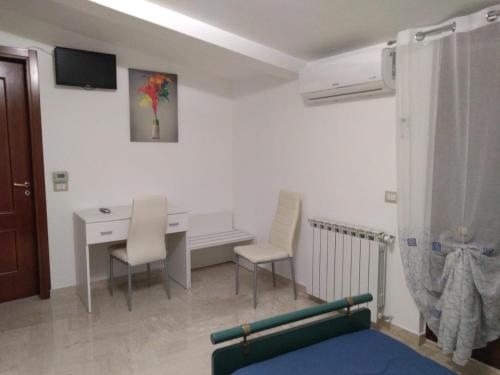 - un salon avec une table, des chaises et un bureau dans l'établissement Affittacamere Casa Quisquina, à Santo Stefano Quisquina