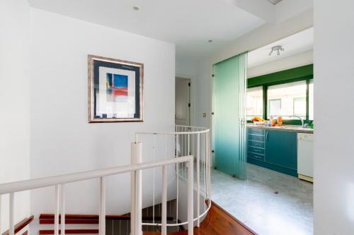 - un escalier dans une cuisine aux murs verts et blancs dans l'établissement Sevilla Central Suites Apartamentos Puerta Jerez, à Séville