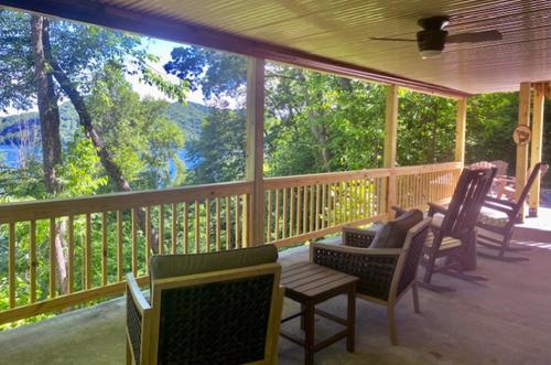a screened in porch with chairs and a table at stayNantahala - Smoky Mountain Cabins in Aquone