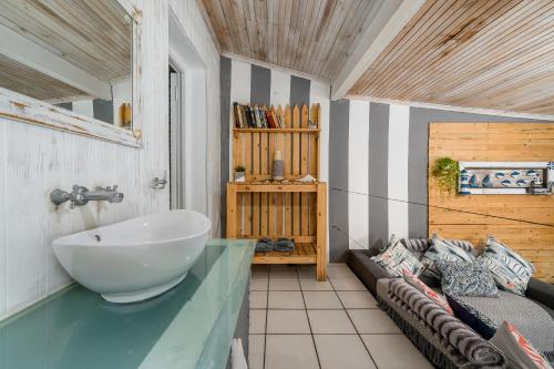 a bathroom with a large bowl sink and a couch at 302 On Old Sea View Road Chelsea in Port Elizabeth