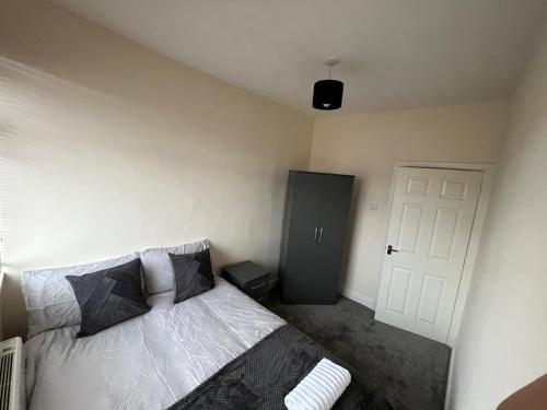 1 dormitorio con cama y pared blanca en conway flat, en Newport