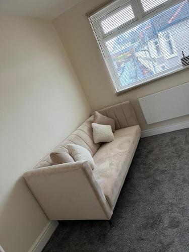 un sofá en la esquina de una habitación con ventana en conway flat en Newport