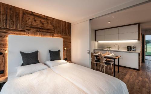 a bedroom with a large white bed and a table at Bellevue Bruneck - Suites & Lofts in Brunico