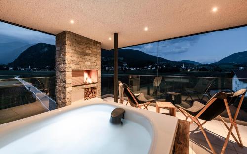 a bath tub in a room with a fireplace at Bellevue Bruneck - Suites & Lofts in Brunico