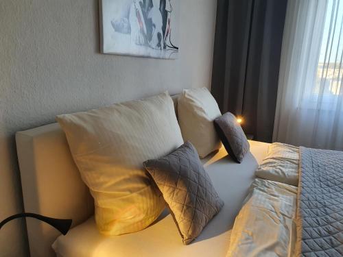 1 cama con almohadas en el dormitorio en LANE City Laatzen en Hannover
