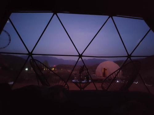 a view from inside a yurt with a table in the dark at Vista Pedra Glamping in Potrerillos