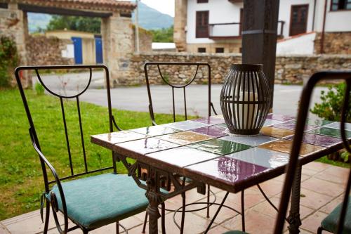 a table with two chairs and a vase on it at Posada Rural Ochohermanas in Las Fraguas