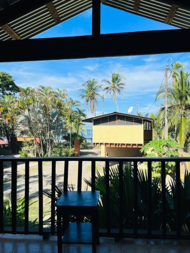 a balcony with a table and a building with palm trees at Perla Negra Beachfront in Puerto Viejo