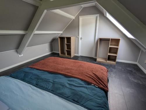 een slaapkamer met een bed op zolder bij Knus appartement aan bosrand in Hornsterzwaag
