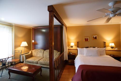 a hotel room with a bed and a couch at Relais St-Denis in Saint-Sauveur-des-Monts