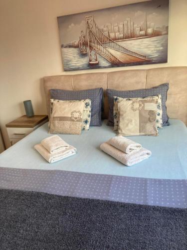 a blue bed with two pillows on top of it at Apartman Anja in Novi Sad