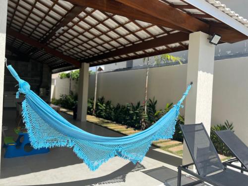 a blue hammock hanging from a pergola at Venha se hospedar no Paraíso de Guarajuba in Camaçari