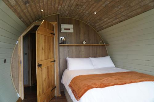 a bed in a small room with a wooden ceiling at Hare's View in Rhayader