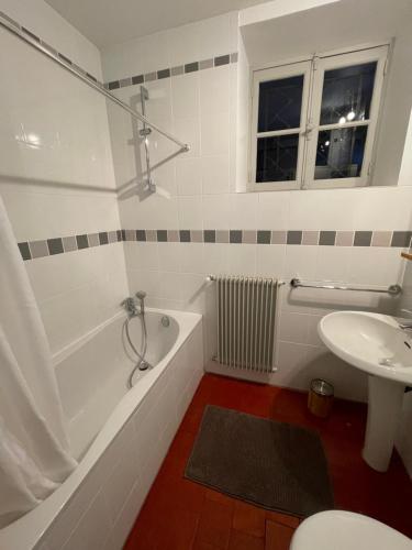 y baño con bañera y lavamanos. en Chez Katia en Semur-en-Auxois