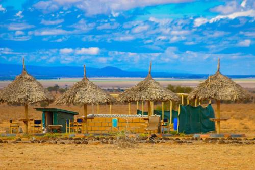 a group of huts in the middle of the desert at Amanya 1-Bed Leopard Tent in Amboseli