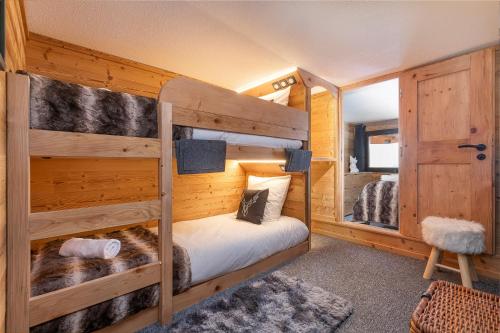a bedroom with two bunk beds in a cabin at Val Thorens - Cosy Duplex Silveralp 004 in Val Thorens