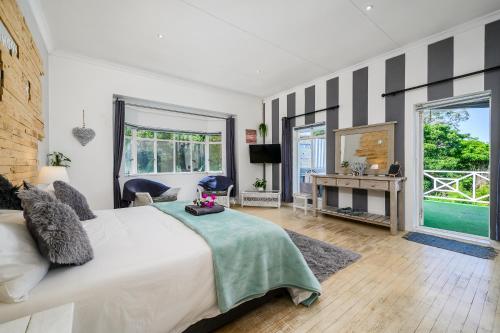 a bedroom with a large white bed and a mirror at 302 On Old Sea View Road Chelsea in Port Elizabeth