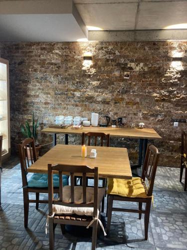 a table and chairs in a room with a brick wall at Guesthouse Relax in Kazbegi in Stepantsminda