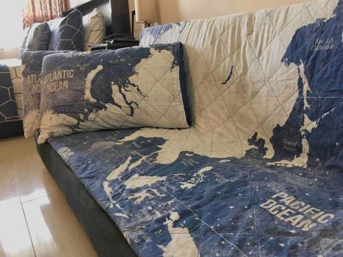 un sofá con una almohada con un mapa en Condo , WIFI up to 100mbps , Infinity Pool, en Cebú