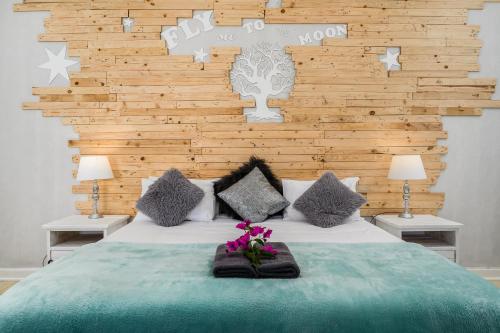 a bedroom with a large bed with a wooden wall at 302 On Old Sea View Road Chelsea in Port Elizabeth