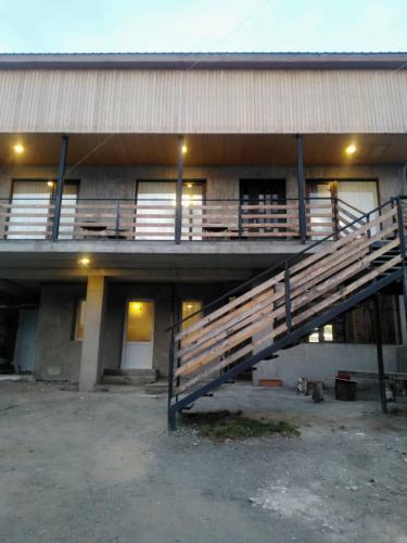 a building with a staircase in front of it at Guesthouse Relax in Kazbegi in Stepantsminda