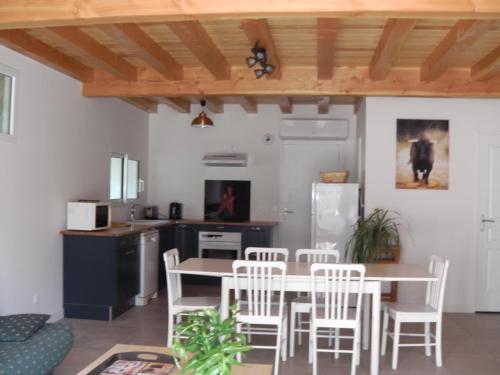une cuisine et une salle à manger avec une table et des chaises dans l'établissement Location meublée au milieu d'un écrin de verdure Aux vieux fours, à Noaillac