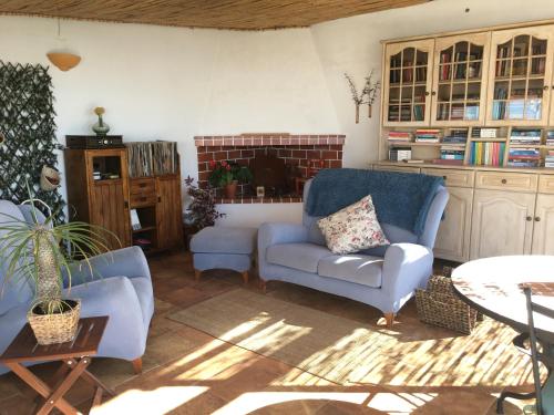 a living room with two blue chairs and a table at Varandas do Vale Furnazinhas in Castro Marim