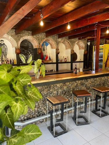 a bar with wooden stools in front of a counter at Perla Negra Beachfront in Puerto Viejo