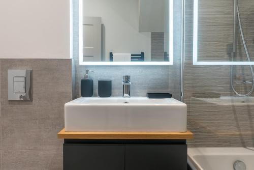 a bathroom with a white sink and a mirror at Spring Mount Huge Luxury Full Apartment- Harrogate Centre-Two extremely comfy Kingsize Bedrooms-Fully equipped Modern Kitchen-Cosy living room with Huge TV in Harrogate
