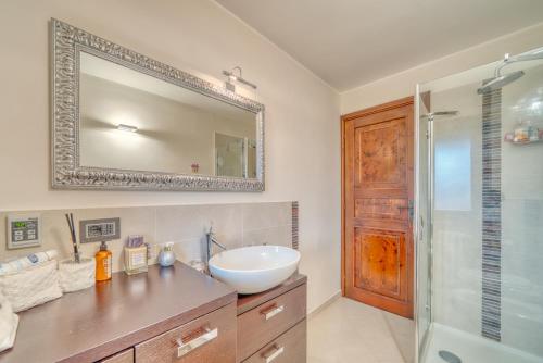 y baño con lavabo, espejo y ducha. en Elegante appartamento-100mt dal centro-50mt dalla seggiovia-wifi-parcheggio gratuito, en Sauze dʼOulx