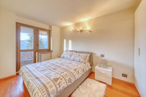1 dormitorio con cama y ventana en Elegante appartamento-100mt dal centro-50mt dalla seggiovia-wifi-parcheggio gratuito, en Sauze dʼOulx