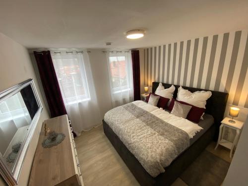 ein Schlafzimmer mit einem großen Bett mit roten Kissen in der Unterkunft Schöne Ferienwohnung „Zum Glück“ in Eisenach