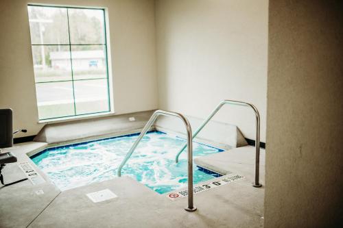 a hot tub in a room with a window at Cobblestone Hotel & Suites International Falls in International Falls