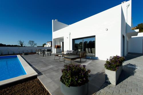 a white house with a patio and a swimming pool at Vakantiehuis Zilverkust Portugal 